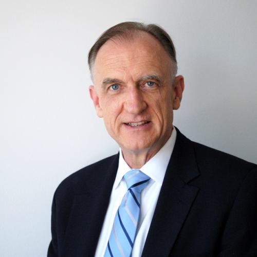 John Mueller, facing forward, black suit, white background